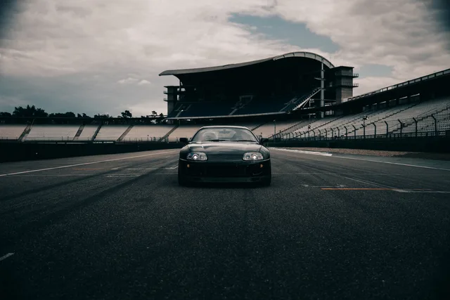 Schwarzer Toyota Supra vor einer leeren Tribüne