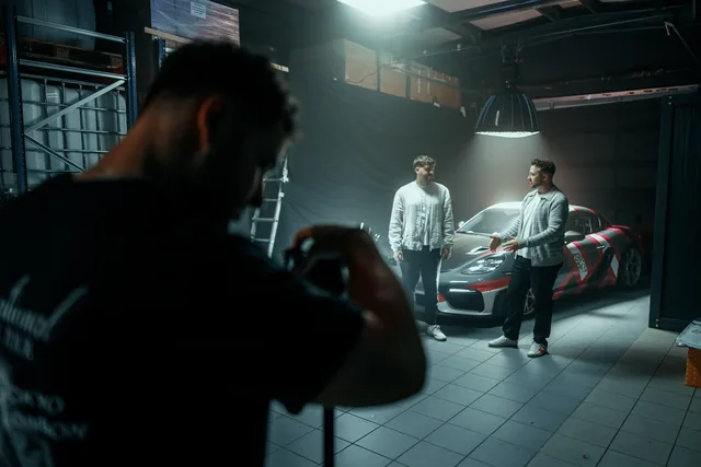 Zwei Freunde am Set neben einem weißen Auto