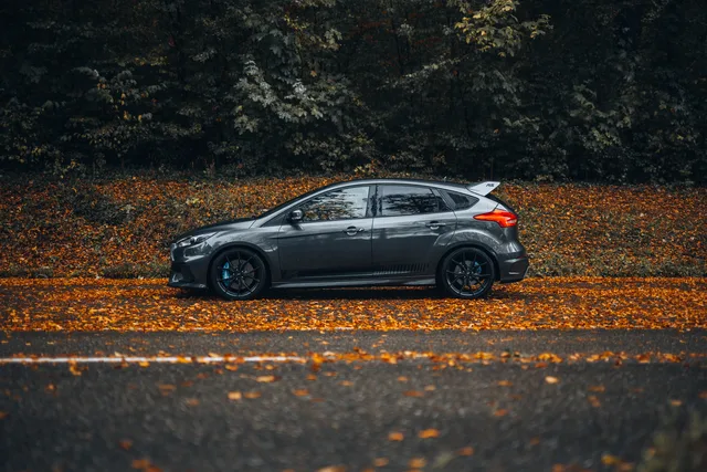 Grauer Ford Focus RS auf einer Straße voller Herbstlaub