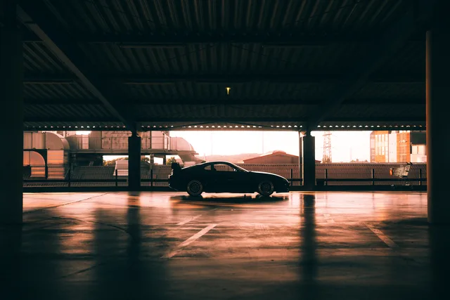 Schwarzer Toyota Supra im warm beleuchteten Parkdeck