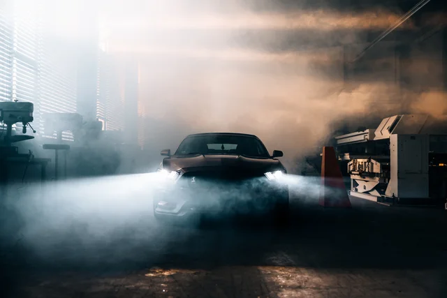Sportcoupé im Nebel einer nächtlichen Halle
