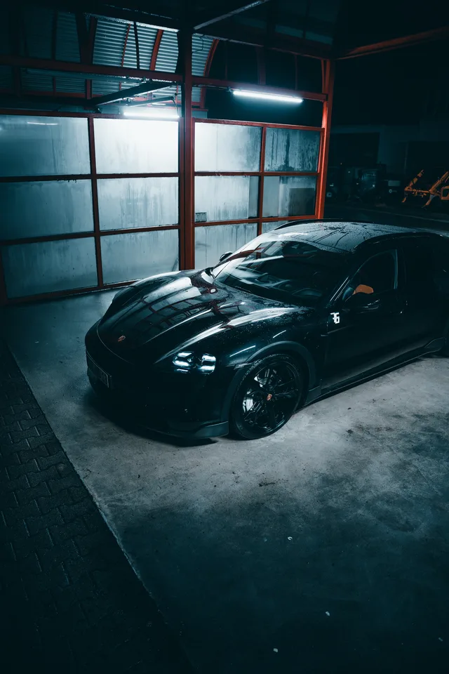 Taycan schräg von vorn in der Halle