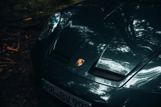 Nasse Haube mit Porsche-Wappen